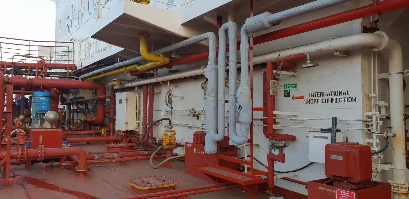 Tanker güvertesinde kırmızı boyalı boru hatları ve manifoldlar